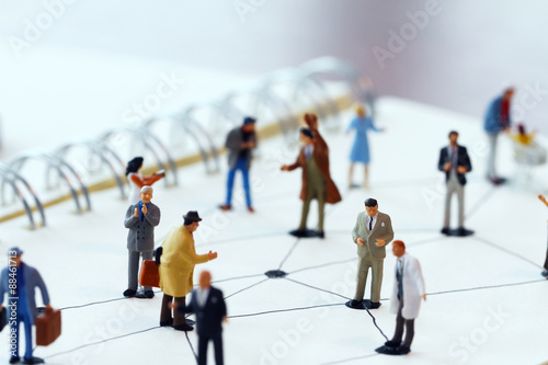 close up of miniature people with social network diagram on open