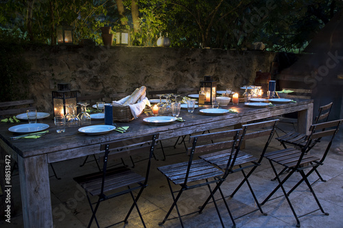 large rustic table prepared for a outside dinner at night