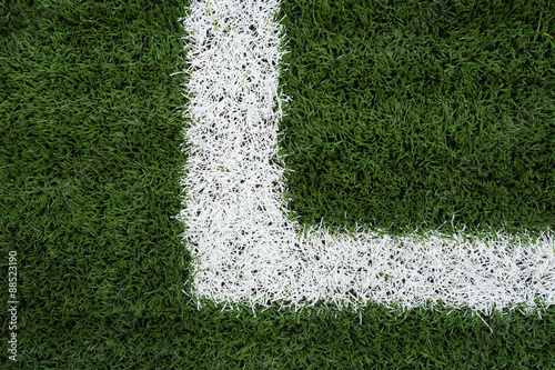 Photo of a green synthetic grass sports field with white line sh