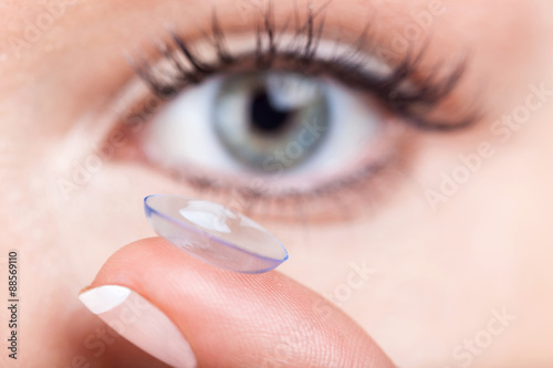 Woman eye with contact lens applying