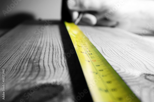 Tape measure wood. Abstract image of a tape measure on a piece of wood.