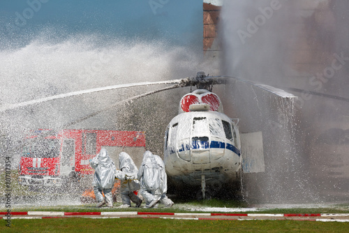 Firefighters in special suits extinguish the fire by helicopter