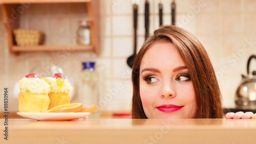 Woman looking at delicious sweet cake. Gluttony.