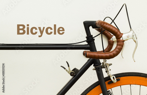 Some of old bicycle on white wall with word on space left side.