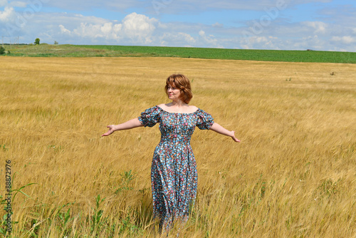 woman in maxi dress standing on rye field