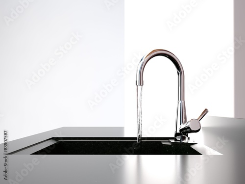 water flows from the kitchen tap to black kitchen sink