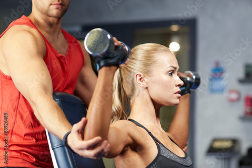 man and woman with dumbbells in gym
