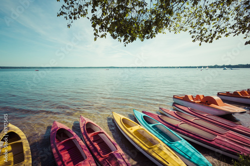 Colorful kayaks moored on lakeshore, Goldopiwo Lake, Mazury, Pol