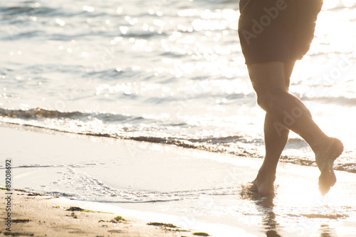 Uomo che corre sulla spiaggia all'alba