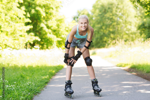 happy young woman in rollerblades riding outdoors