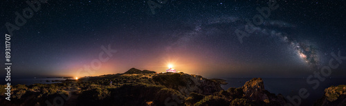 Prostoliniowy widok 360 ° gwiaździstej nocy z łukiem Drogi Mlecznej i latarnią morską Capo Spartivento