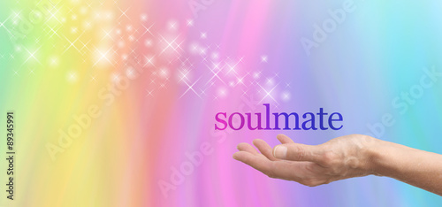 Seeking a Soulmate - female hand palm up with the word Soulmate floating above, surrounded by a spiral of pastel colored soft focus love hearts on a bokeh background