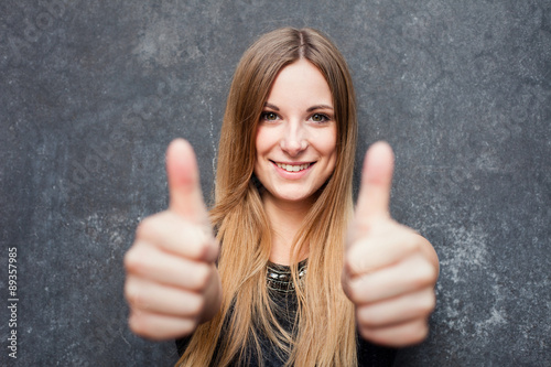 Teenage girl showing thumbs up with both hands