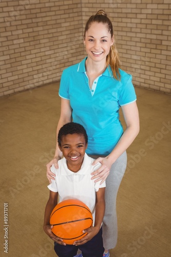 Student holding basketball with teacher