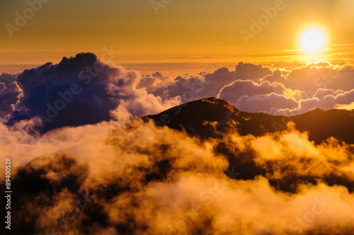 Sunrise over clouds and distant mountains from Haleakala Crater.