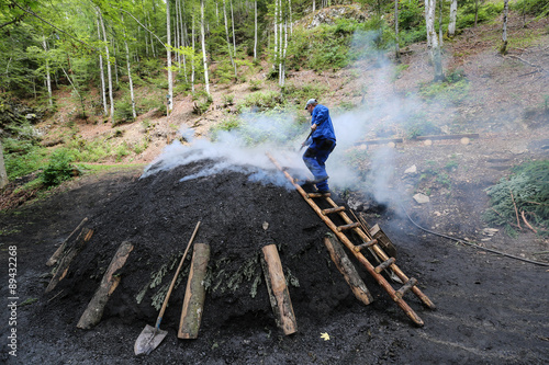 Rauchender Kohlenmeiler im Schwarzwald nach traditionellem Köhler - Handwerk aus reinem Buchenholz hergestellt