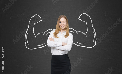 A beautiful lady in formal clothes with drawn powerful hands. Black chalkboard background.