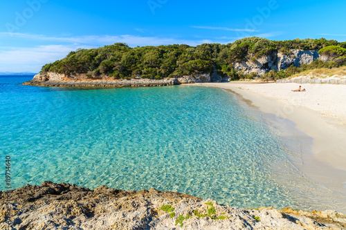 Unidentified young couple relaxing on beautiful Petit Sperone beach, Corsica island, France