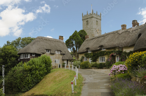 The pretty thatched cottages of Church Hill, with All Saints church in the background.l