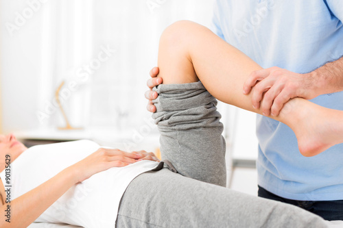 Young attractive woman being manipulated by physiotherapist