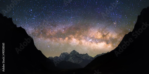 Miska Niebios. Jasna i żywa galaktyka Drogi Mlecznej nad zaśnieżonymi górami. Piękne gwiaździste nocne niebo wydaje się znajdować w „misce” między sylwetkowymi wzgórzami.