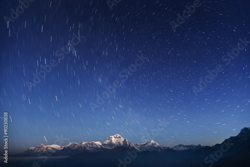 Night laconic landscape. Starry sky over the snowy mountains. 