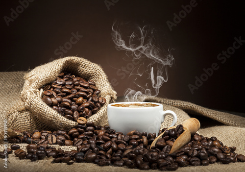 White cup with coffee beans on dark background