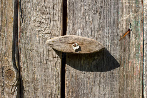Old wooden door lock on an old plank wall