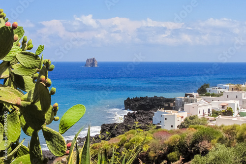 Coastline of Stromboli with prickly pear and white houses; Strombolicchio stack in the background