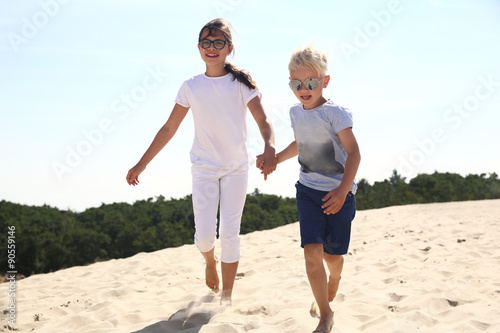Szczęśliwe dzieci biegają po złotej plaży