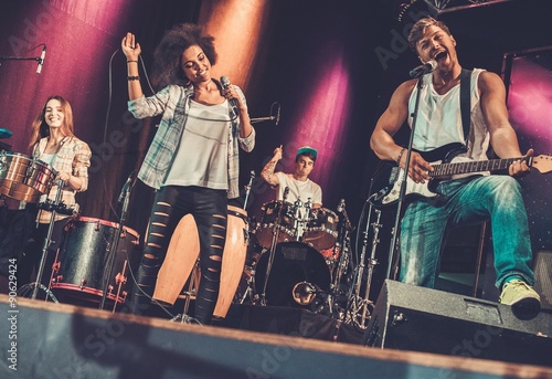 Multiracial music band performing on a stage