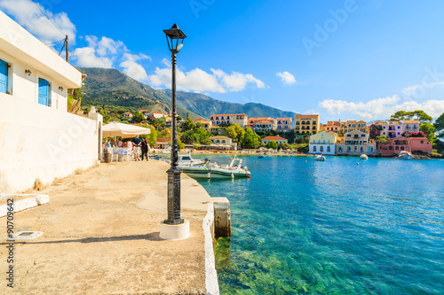 Coastal promenade along sea bay and colorful houses of Assos port on Kefalonia island, Greece