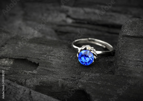 jewellery ring witht big blue sapphir on dark coal background, s