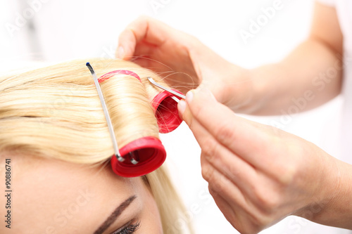 Wałki do włosów.Kobieta w salonie fryzjerskim, fryzjer kręci włosy na wałki 