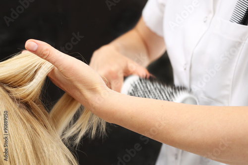 Kobieta u fryzjera, fryzjer modeluje włosy na okrągłej szczotce