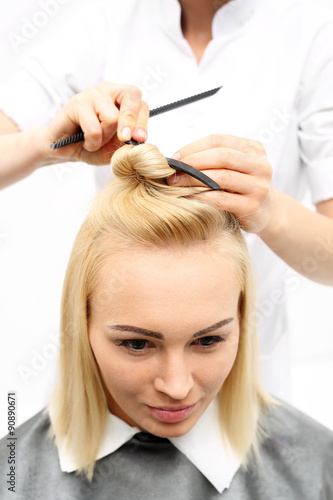 Włosy półdługie, kobieta u fryzjera. Kobieta na fotelu fryzjerskim podczas zabiegu stylizacji włosów