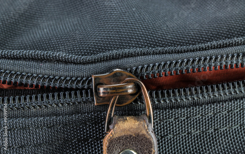 Old and damaged zipper on black cloth