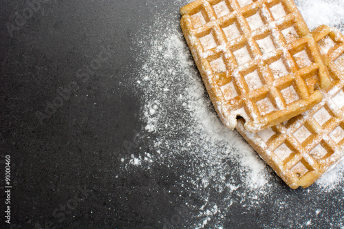 Waffles with sugar on slate table