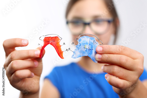 Dziewczynka z kolorowymi aparatami ortodontycznymi 