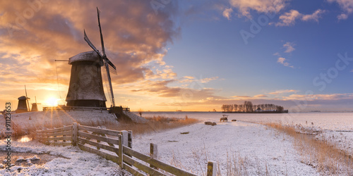 Traditional Dutch windmills in winter at sunrise