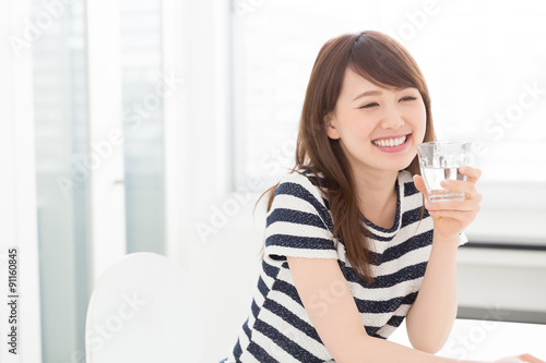 部屋で水を飲む女性