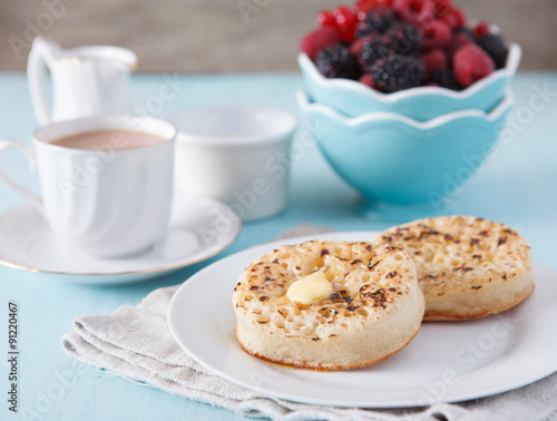 Hot buttered crumpets on the blue table with tea