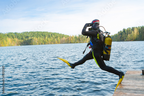 The diver jumps into the forest lake