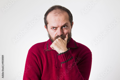 Man in red sweater, with beard and mustaches, confused and skeptic