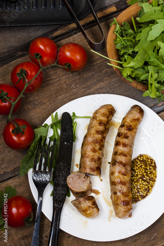 sausages on the grill with tomatoes and arugula