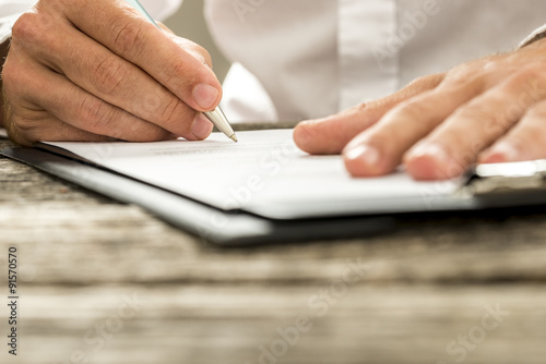 Low angle view of male hand signing contract or subscription for