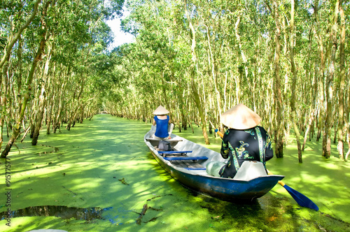 Tourism rowing boat in Tra Su flooded indigo plant forest in An Giang, Mekong delta, Vietnam. 
