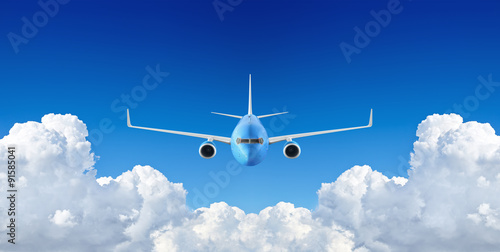 Passenger airplane flying in the blue sky among the clouds