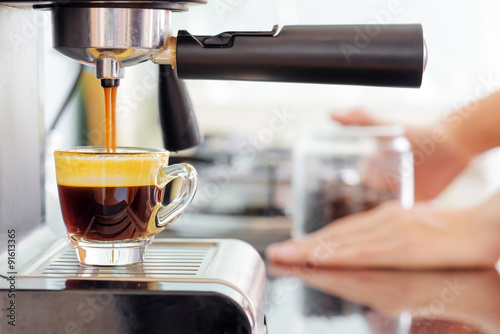Espresso coffee machine in kitchen. Coffee pouring into cup