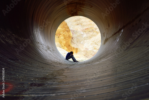 depressed young man sitting in the drain